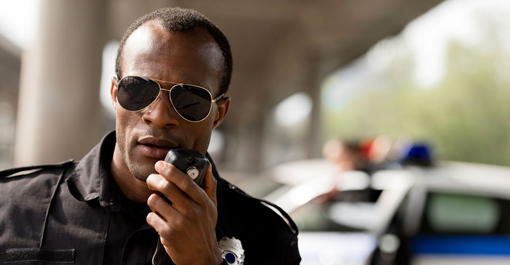 Police officer on walkie-talkie radio at emergency response